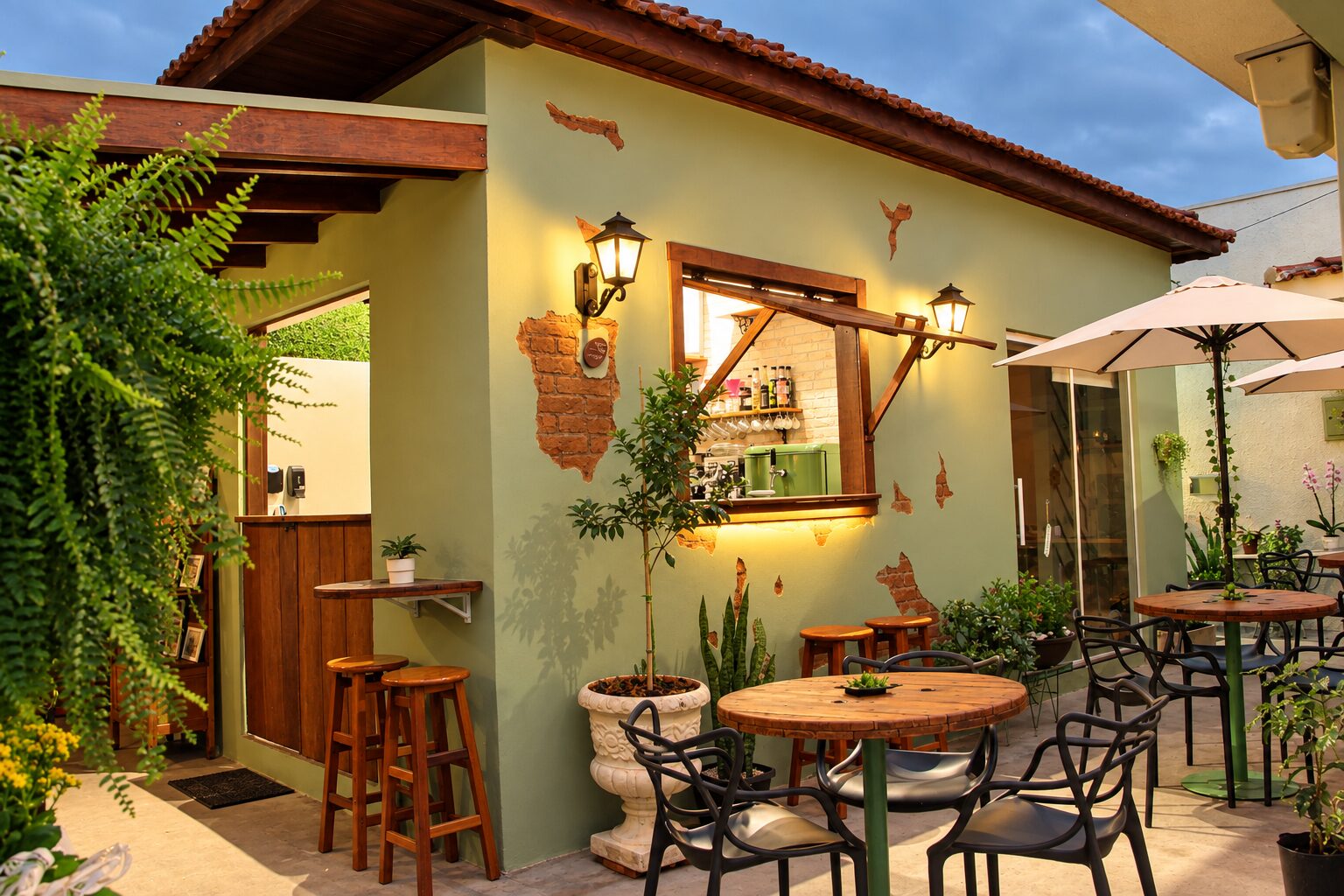 Fachada do Espaço Casa 11 em Limeira, com paredes verdes, pátio externo e mesas